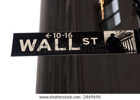 Wall Street street sign against sky and buildings