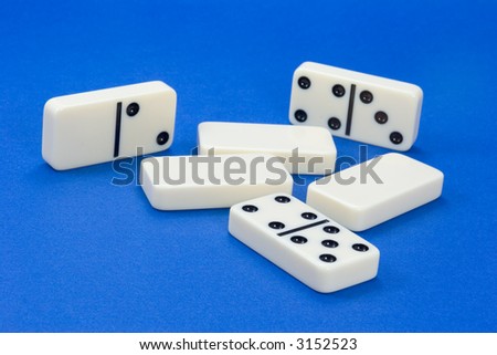 Group of dominoes on background of blue artist paper
