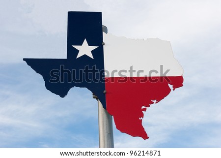 Metal Texas road sign against a cloudy blue sky.