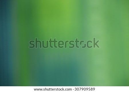 Green abstract defocused background. Green color hue picture with yellow glare. Full frame picture
