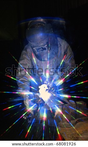 Skilled craftsman using electric arc welding equipment to join steel plate.