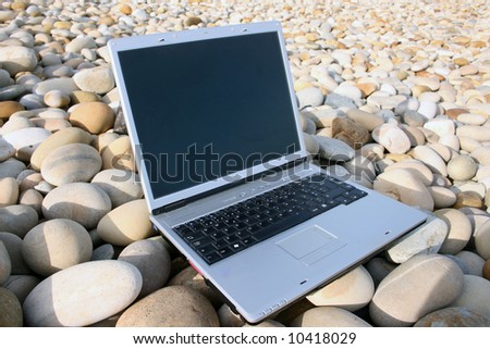 One portable computer on a stone background