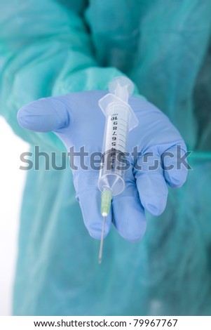 Syringe in hands in protective medical gloves