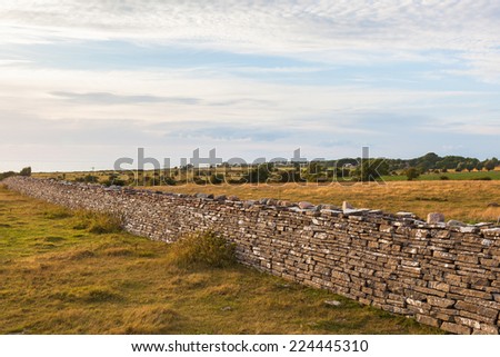 High stone wall in the landscape at sunset