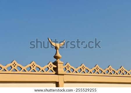 Wood decorations with a crescent Moon on a house roof