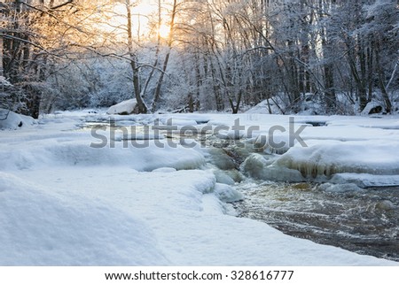 Sunset in the woods by the river with snow and ice