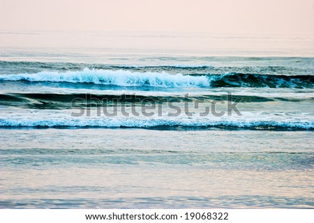 Waves come in to the beach in a beautiful evening light