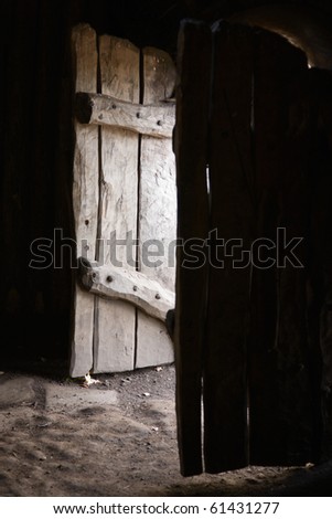Old wooden doors open to a shed from the inside