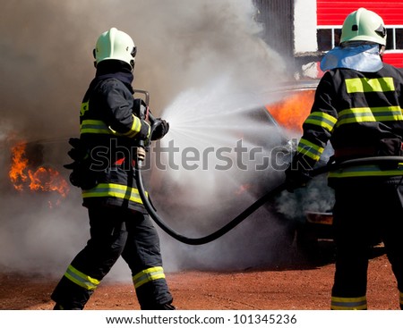 The firemans are extinguish a exploded burning car