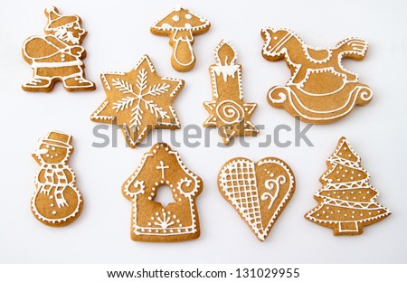 Homemade Christmas Ginger and Honey cookies on white background. Star, fir tree, snowflake, horse, bell, mushroom, Santa Claus, snowman, rocking horse, candle, heart - shapes.