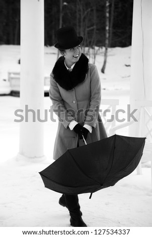 Shaded woman try close black umbrella on walk