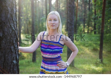 Zoomed woman in lined dress on forest background