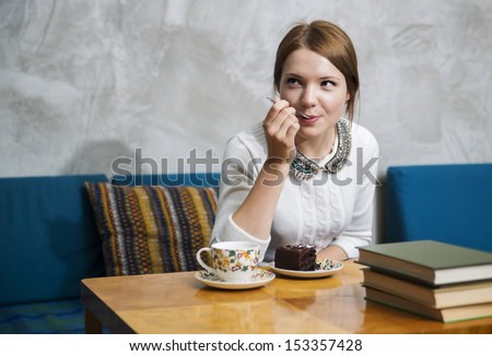 Woman eat cake with great pleasure  at cafe