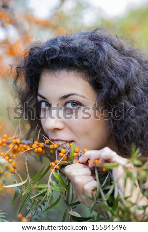 Zoomed view of woman eat gooseberries from branch