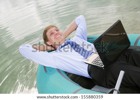Satisfied man lay in boat and smile sincerely