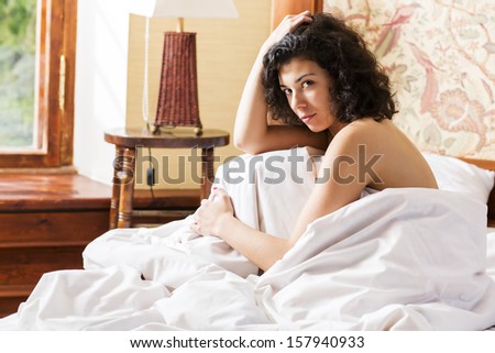 Woman under soft cover stroking her curly head