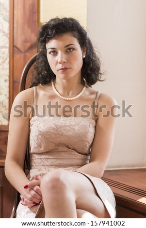 Woman on wooden chair with pretty serious look