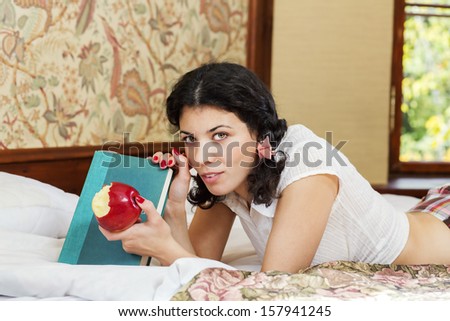 Woman in schoolgirl hold eated apple and book