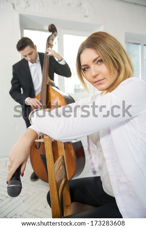 Woman backwards on chair holding microphone at hand