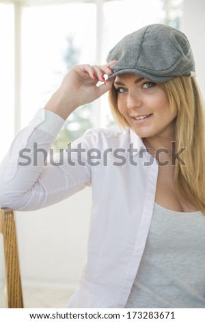 Young woman on chair with stylish grey hat