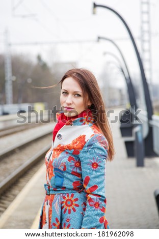 Young woman at mottled suit waiting delayed train