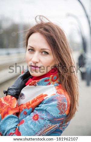 Zoomed young woman adjust hair at windy day