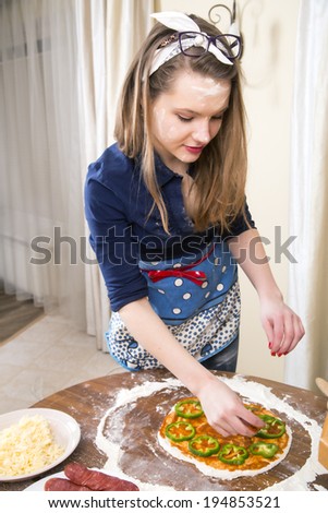 Woman at sexy suit decorating small vegan pizza