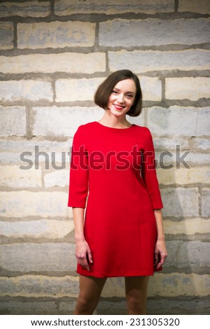 Young woman in hallway stand on limestone wall