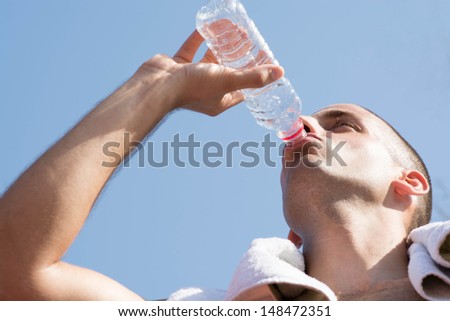 Young handsome man drinking water.
