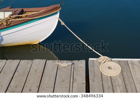 Wood Skiff Tied At Dock with Flemish Coil