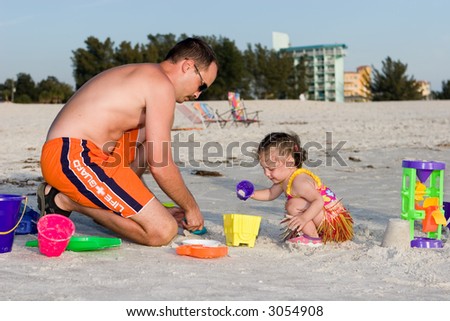 Father and daughter building a sandcastle on the public beach in Treasure Island, Florida.