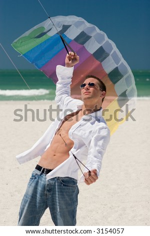 A young man working the control lines of a stunt kite on the beach in Treasure Island, Florida.