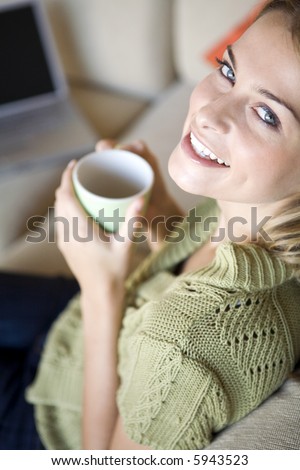 A young woman with her laptop and a mug of coffee