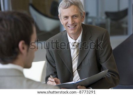 Smiling mature consultant talking with a client