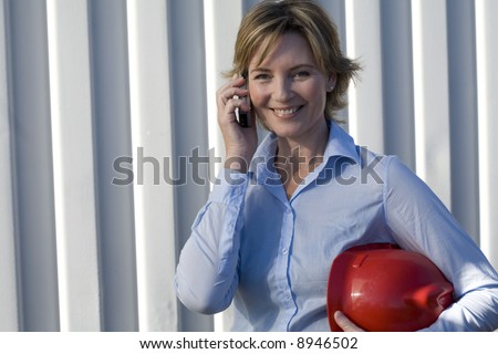 Relaxed woman industrial inspector on her cell phone