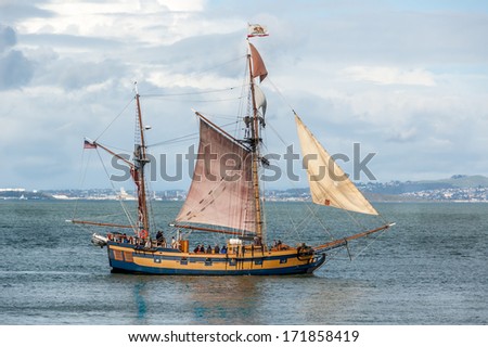 Small wood sailing ship plys waters in San Francisco Bay, California.