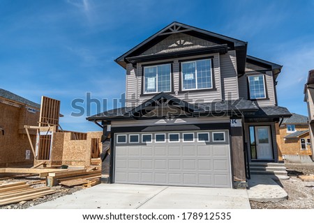 CALGARY, CANADA - AUG 11, 2007: Suburban home under construction in Royal Oak in Calgary, Alberta. This grey two-story suburban home is typical of Calgary outlying residential districts.