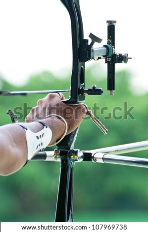 An archer with bow takes aim at a target during competition