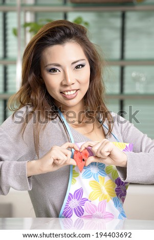 Happy asian woman cooking in the kitchen