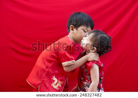 China boy and girl  in traditional Chinese red Tang suit greeting