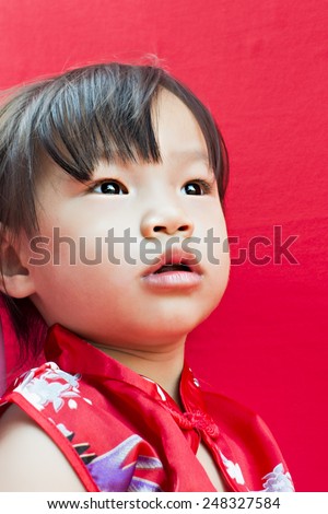 China girl in traditional Chinese red Tang suit greeting