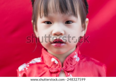 China girl in traditional Chinese red Tang suit greeting
