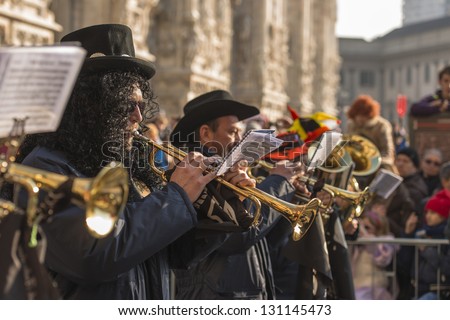 MILAN, ITALY - FEBRUARY 16: brass players of a band in parade, in background blurred Minster. Shot at Kid\'s Carnival parade on Minster square on feb 16, 2013 Milan, Italy