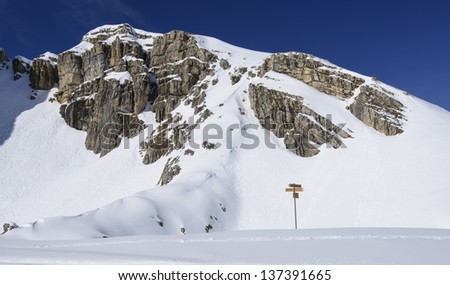 guide post at Piz Boe', Corvara; guide post in front of sharp cliffs of famous mountain in Dolomites, shot under deep blue sky