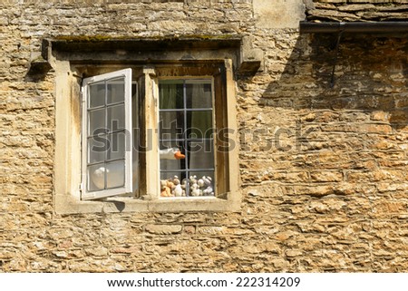 fake goose at stone window , Lacock a wooden goose sticks out of a stone window of cottage in historic touristic village of Somerset