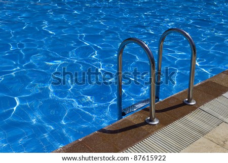 Pool ladder close up. Blue swimming pool