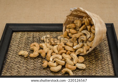 Image of cashew nuts in bamboo woven bowl on bamboo tray