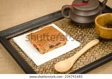 Image of fruit cake with Chinese tea set in bamboo tray