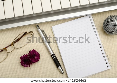 Part of keyboard with blank paper and pen