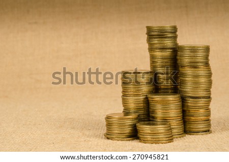 Stack of gold coins on brown sack background